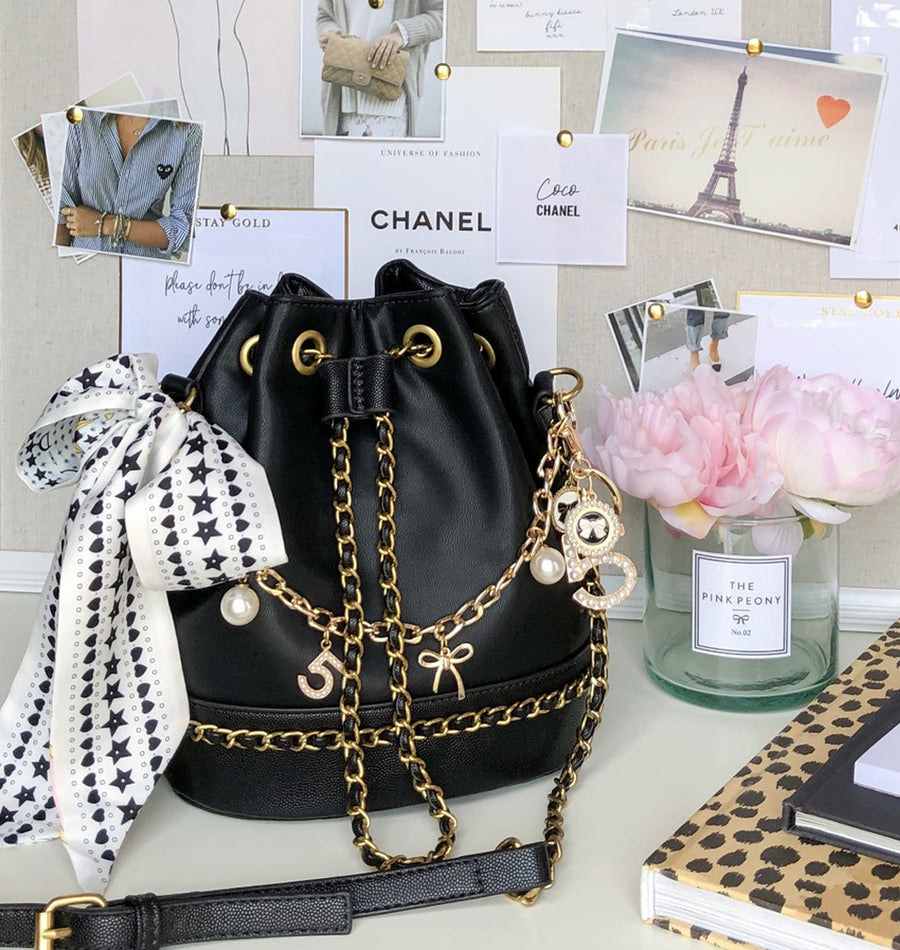 Chanel black bucket bag with logo on the front and gold detail